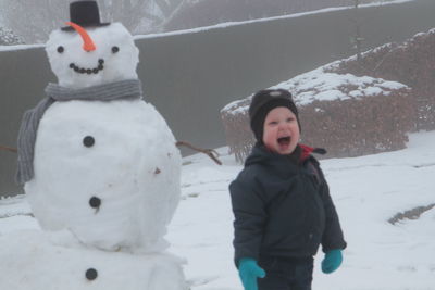 Portrait of cute boy with snow during winter