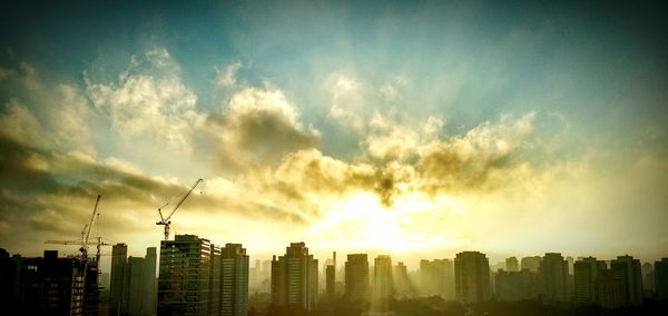 Skyscrapers in city at sunset