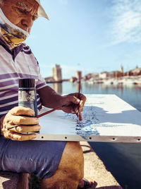 Man holding ice cream on table against sky