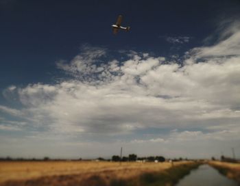 Scenic view of field against cloudy sky