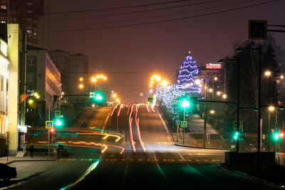 Illuminated light trails on road in city at night