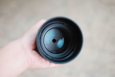 Cropped hand of person holding camera lens