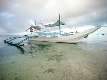 Boat moored on sea against sky