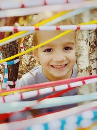 Close-up of cute baby girl standing in cage