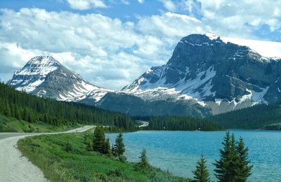 Scenic view of lake by snowcapped mountains against sky