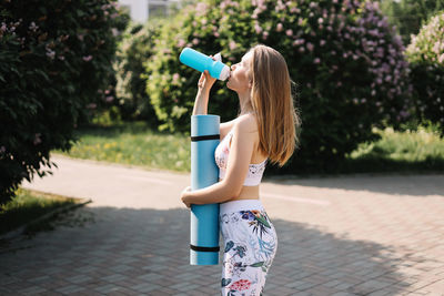 Happy fun healthy athletic girl in sportswear training and exercising in the park in nature outdoors