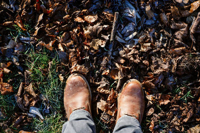 Low section of man standing on messy field