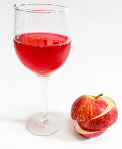 Close-up of red wine in glass against white background