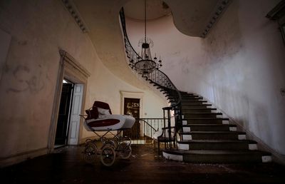 Baby carriage by steps at abandoned home