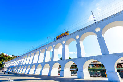 Low angle view of bridge against blue sky