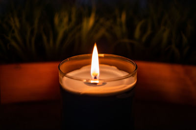 Close-up of illuminated tea light candle on table