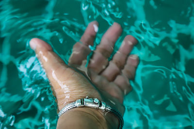 High angle view of woman hand in swimming pool
