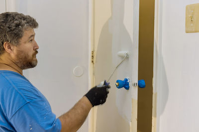 Side view of man working against wall