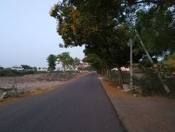 Road amidst trees against sky