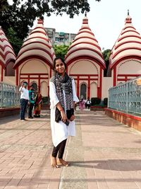 Rear view of woman standing against building