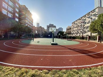 View of empty road by buildings against sky