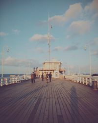Pier on sea against cloudy sky