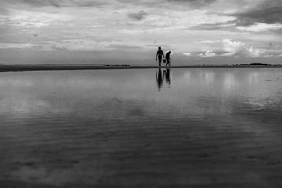 Man standing in sea against sky