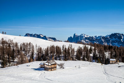 Scenic view of snow covered mountains against blue sky