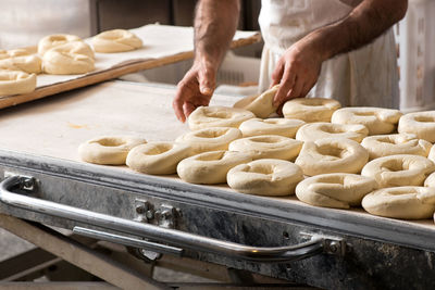 Midsection of man preparing donut