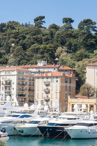 Boats moored at harbor against buildings