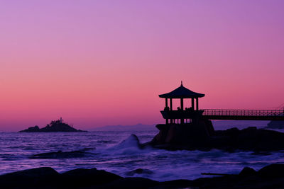 Built structure on beach during sunset