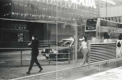 Reflection of man walking on glass window