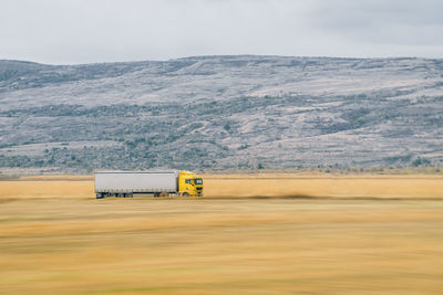 Truck on landscape against mountain