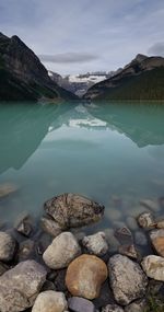 Scenic view of lake by rocks against sky