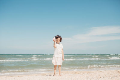 Full length of man standing on beach against sky