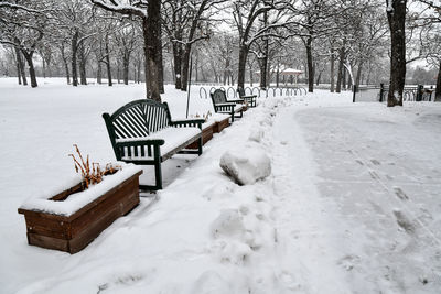 Park bench along the path in winter snow