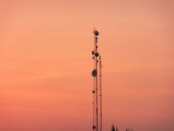 Low angle view of communications tower against sky during sunset