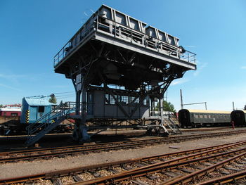 Train on railroad tracks against blue sky