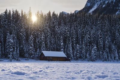 Built structure on snow covered field against sky