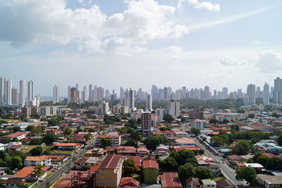 Aerial view of buildings in city against sky