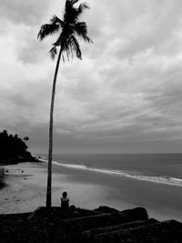 Silhouette palm trees on beach against sky