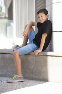 Full length of boy sitting outdoors