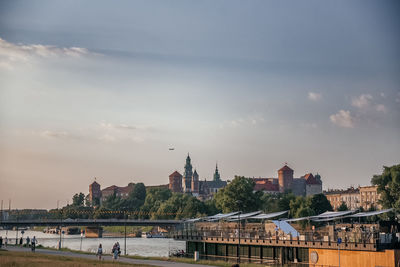 Buildings in city against sky during sunset