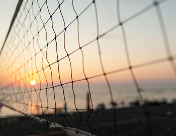 Scenic view of sea seen through chainlink fence