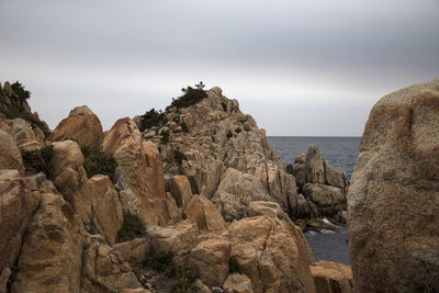 Rock formations in sea against sky