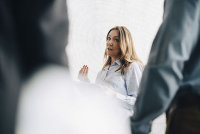 Businesswoman discussing with male entrepreneurs at conference