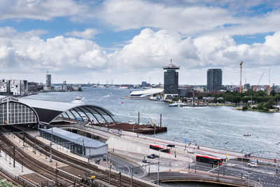 High angle view of bridge over river by buildings against sky