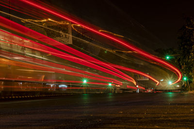 Light trails on road against sky at night