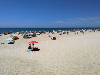 People at beach against sky