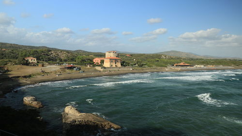 Scenic view of sea by buildings against sky