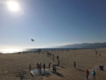 People at beach against clear sky