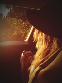 Woman reading message on her smart phone in car