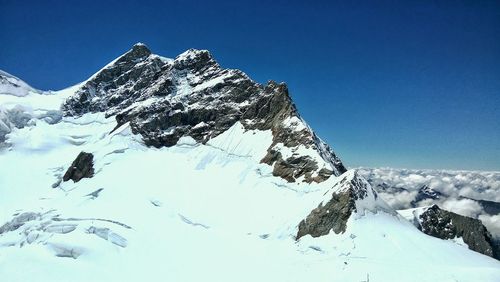 Scenic view of snowcapped mountains against clear blue sky