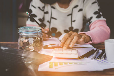 Midsection of woman doing paperwork at desk