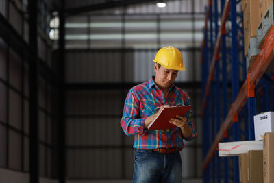 Man working with umbrella standing in building